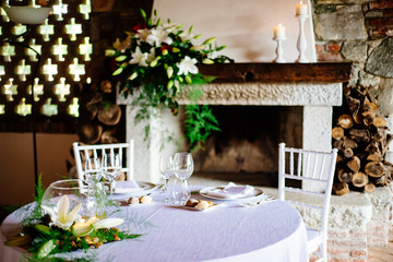 hall with table set for wedding party lit candles