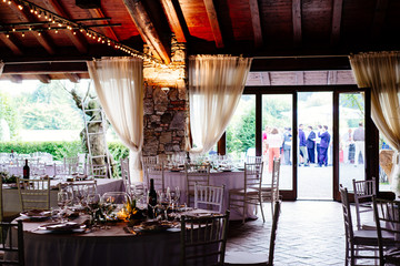 hall with table set for wedding party lit candles