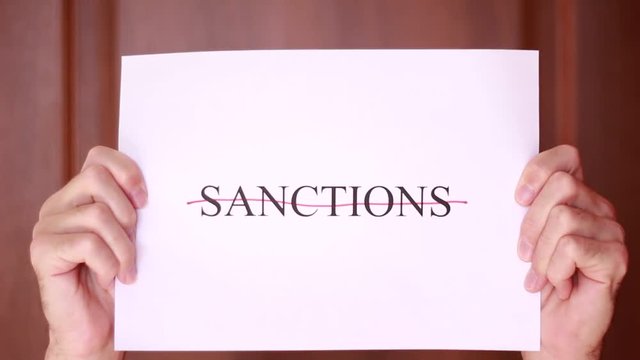 Holding "Sanctions" inscription crossed with red line