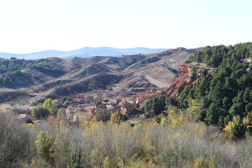 Obraz premium A landscape of the cultivated fields in a valley, with autumn colors, tilled earth, trees and a blue sky, around Anento, a small spanish village in the Aragonese Spain
