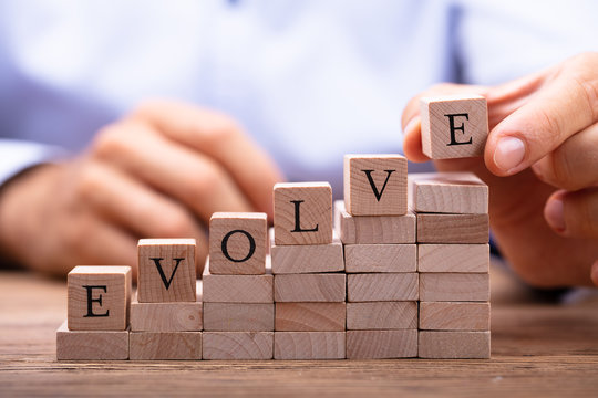 Person's Hand Placing Last Alphabet Of Word Evolve