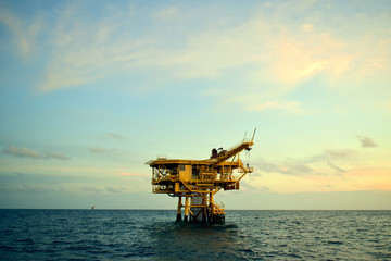 Offshore oil and gas industry, well head remote platform where produced raw gas and crude oil for sent to central processing platform, surface tools of well service worker on deck.