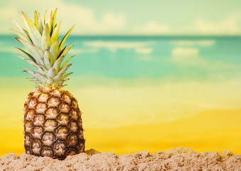 Fresh pineapple on sunny bright beach in warm summer