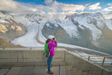 Fototapeta na wymiar Photographer taking photos of the amazing glacier view in Gornergrat, Switzerland
