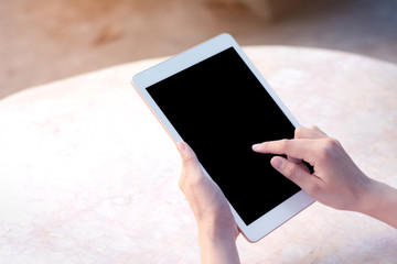 Hand holding smartphone or tablet on table backgrond