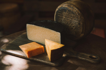 various sorts of delicious cheese on rustic wooden table