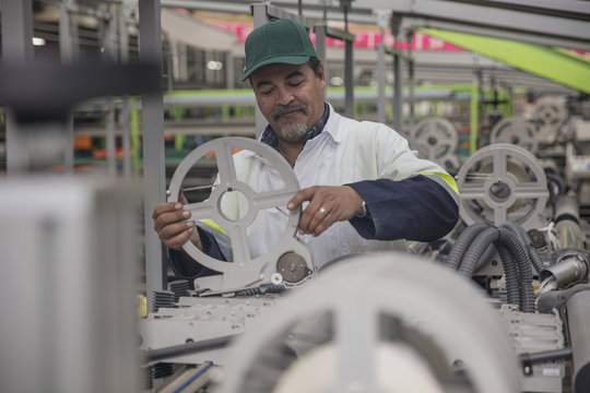 Worker checking label machine