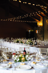 hall with table set for wedding party lit candles