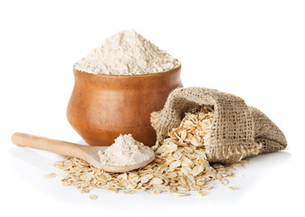 White flour in bowl and wheat ears isolated on white