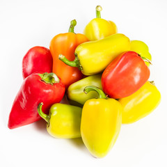 pile of various fresh bell peppers on white