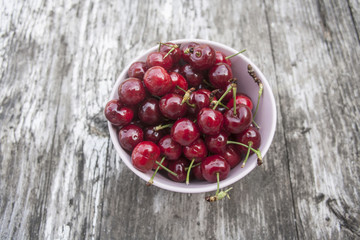 Bowl of cherries on a worn wooden background