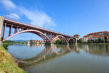 Fototapeta na wymiar Drava river, sky reflection and bridge. The Main Bridge across Drava river in Maribor, Slovenia