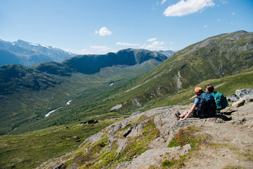 Fototapeta na wymiar couple of hikers sitting on Besseggen ridge in Jotunheimen National Park, Norway
