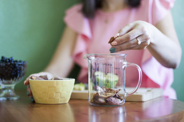 Девушка высыпает сушеные яблоки в мерный стакан