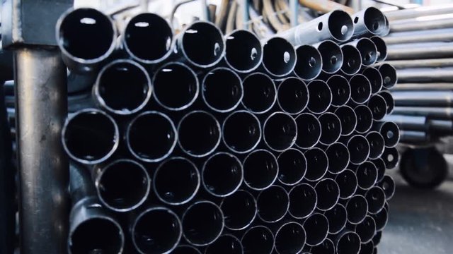 Metal pipe of round section in packs at the warehouse of metal products. Close-up of metal pipe. Warehouse for finished products of metal pipes of circular cross-section at the factory.