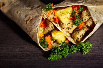 Chicken and pineapple tortilla wrap on dark background
