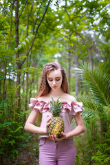 Obraz premium a young teenager girl in pink holding a pineapple