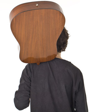 Guy standing back to camera and keeping gitare on his shoulder