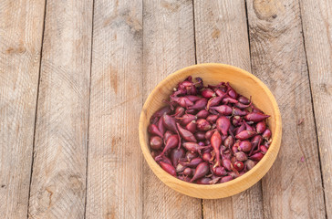 Bowl with a small onion for planting   on a wooden table