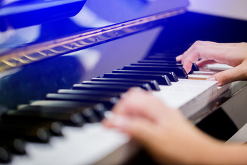Obraz premium Selective focus to fingers of woman teaching boy to play the piano.