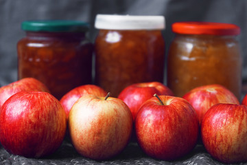 Apples on the background of jars with jam in defocus
