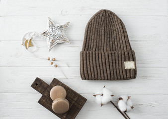 Knitted hats, cotton sprigs, macaroons close-up on a white