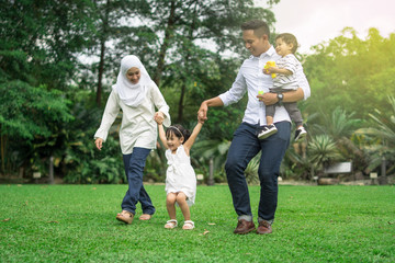 malay family having quality time in a park with morning mood - obrazy, fototapety, plakaty