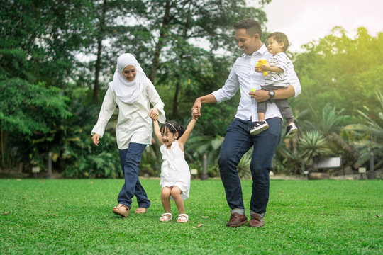 malay family having quality time in a park with morning mood