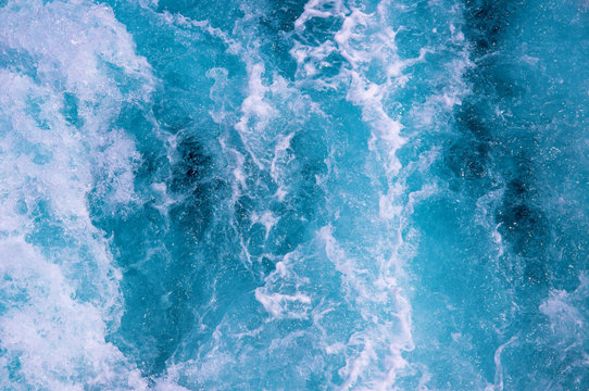 Sea water with foamy surface. Tropical islands boat travel. Cruise ship trail. Blue boiling ocean water top view.