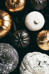top view of traditional festive golden, black and white painted pumpkins for halloween party