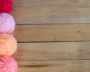 Colorful yarn balls isolated on a wooden background.