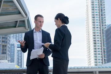 Angry caucasian manager stand and holding document on hand, he blaming employee women for work mistakes.