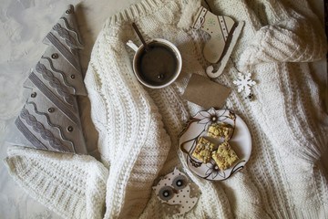 Fototapeta na wymiar A cup of coffee, woolen sweater and Christmas decorations. Winter still life.