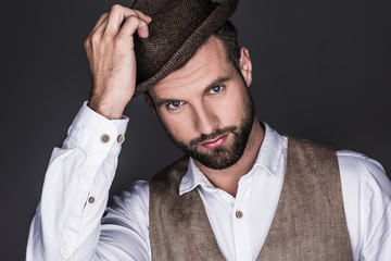 portrait of handsome bearded man in stylish hat, isolated on grey