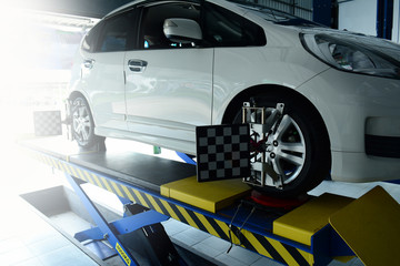 the mechanic install the tool with the wheel of the car that parked on the pedestal during the...