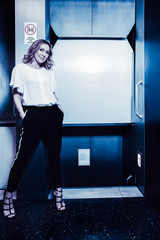 Dark color toned picture of fashionable sexy girl in the elevator.