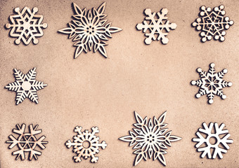 Wooden snowflakes frame on craft paper