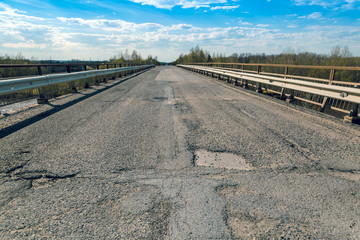 Broken concrete road on the bridge over the river