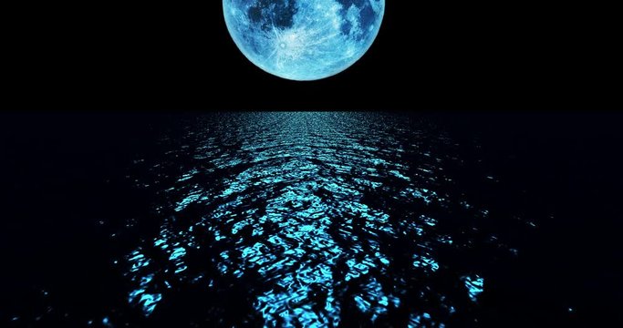 Blue colored moon setting slowly over the ocean at night.