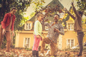 Obraz na płótnie Canvas Falling leaves and my family. This autumn season is so funny.