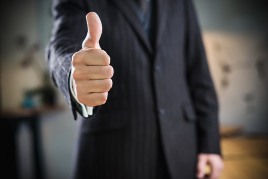 Businessman shows  thumb up gesture