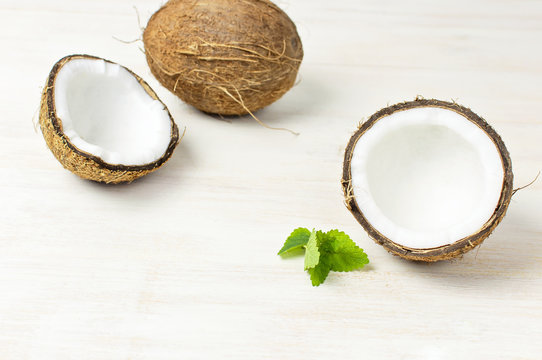 Ripe coconut on a light wooden background, minimal flat lay style. Creative summer and food concept. Tropical fruit
