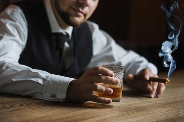 Atmospheric photo of luxury alcoholic drink. Elegant man in white shirt with cufflinks drinks...