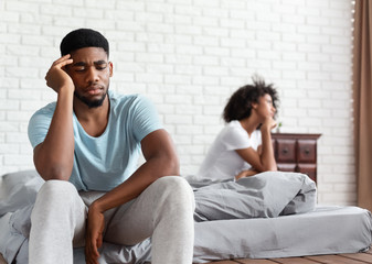 Upset couple ignoring each other in bed