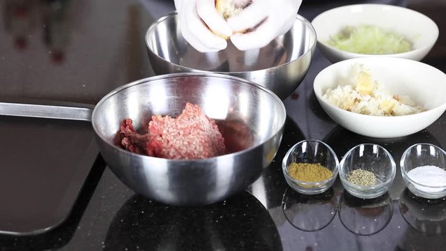 chef is preparing meatball with mince, egg and bread
