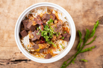 Northern Thai food (Kanom Jeen Nam Ngeaw) with vegetables on wooden background,spicy rice noodles soup