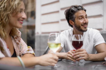 Toghetherness concept: mid-aged friends drinkin wine in a oudoor bar.
