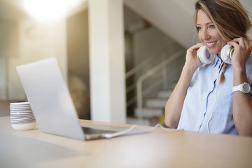 Blond woman at home connected with laptop