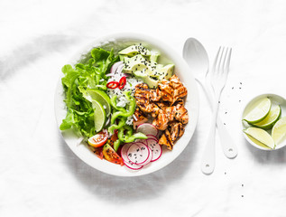 Coconut rice, grilled salmon and vegetables buddha bowl. Healthy lunch - rice, red fish, salad, avocado, radish, tomatoes on a light background, top view