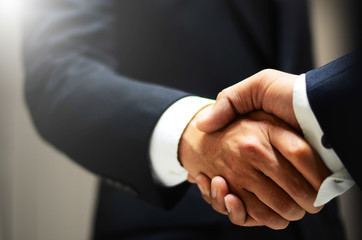 Two business people are holding hands to business cooperation
